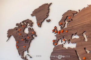 Notenhouten wereldkaart met oranje magneten